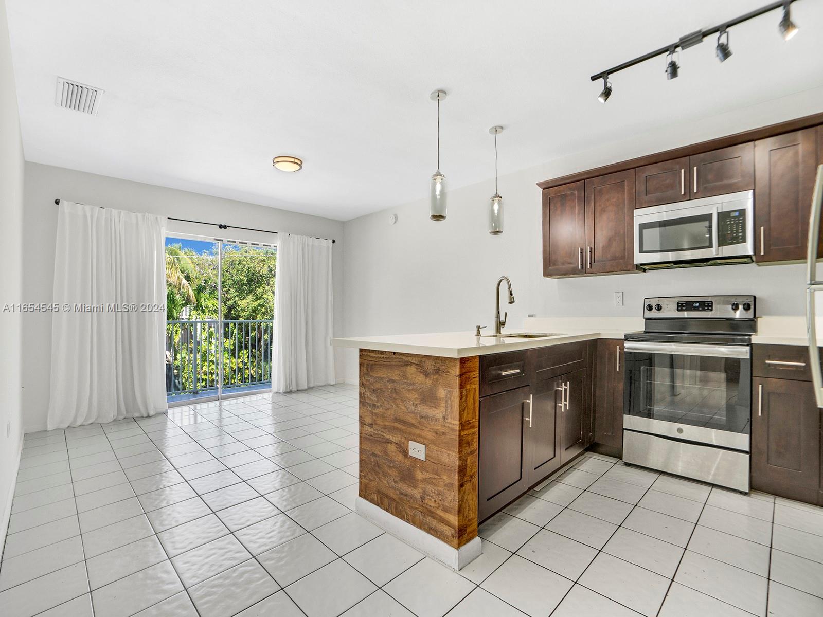 a kitchen with stainless steel appliances a stove sink and microwave