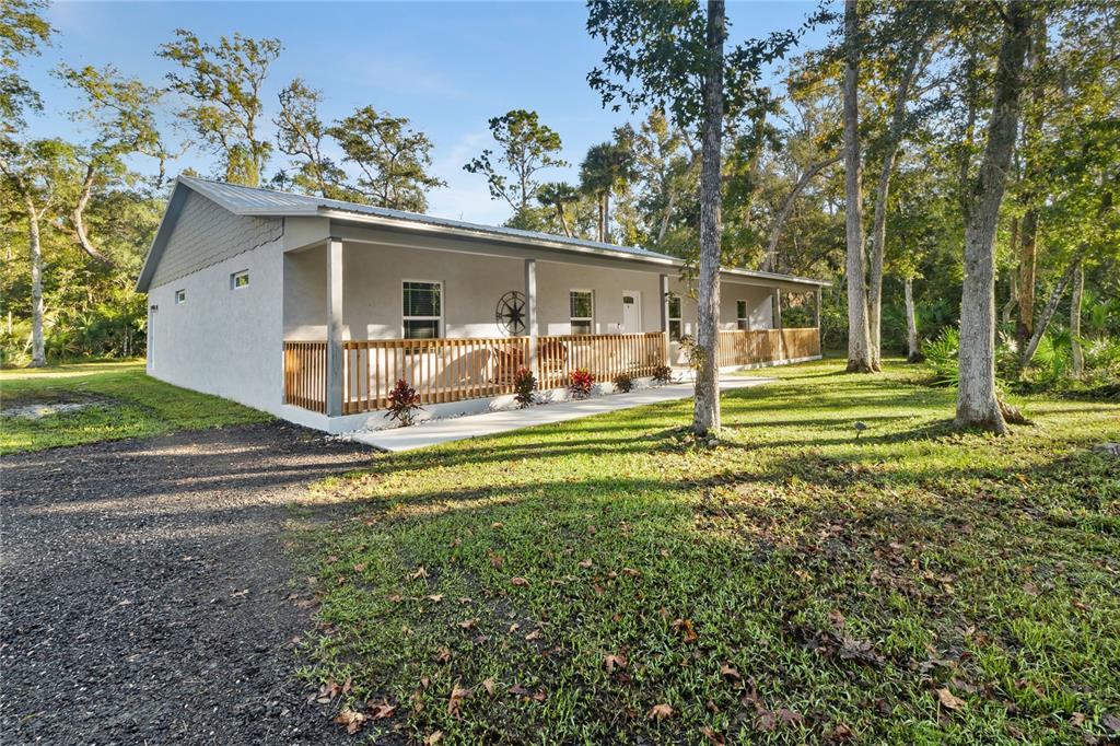 a view of a house with backyard and trees