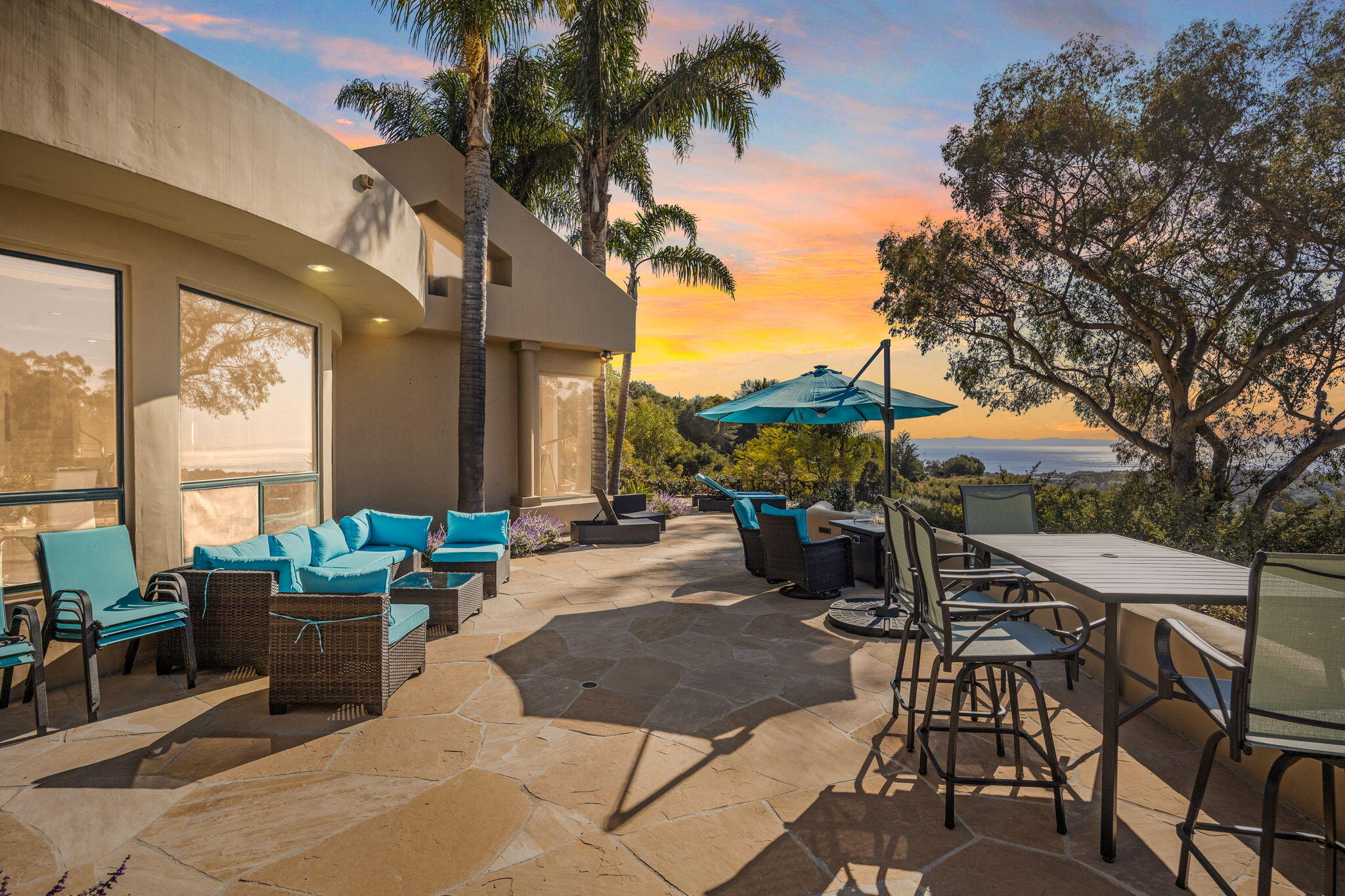 a view of a patio with couches table and chairs and potted plants