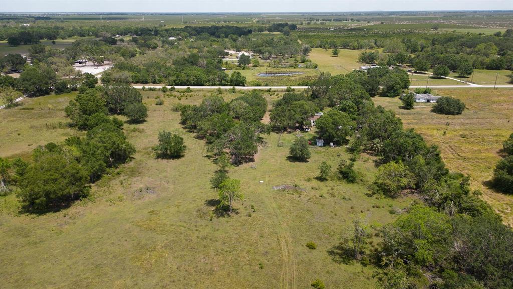 an aerial view of residential houses with outdoor space and trees