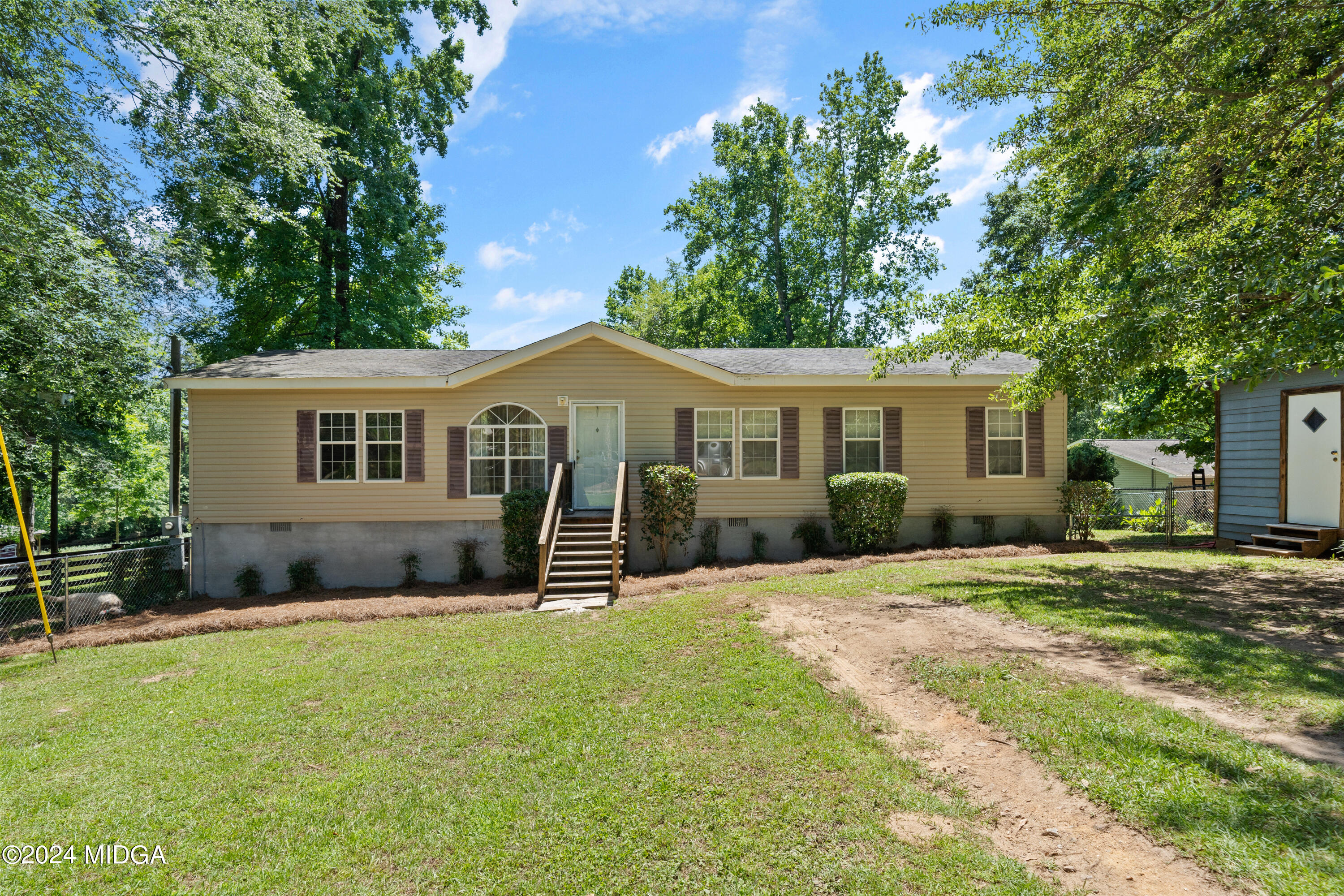 a front view of a house with a yard and trees