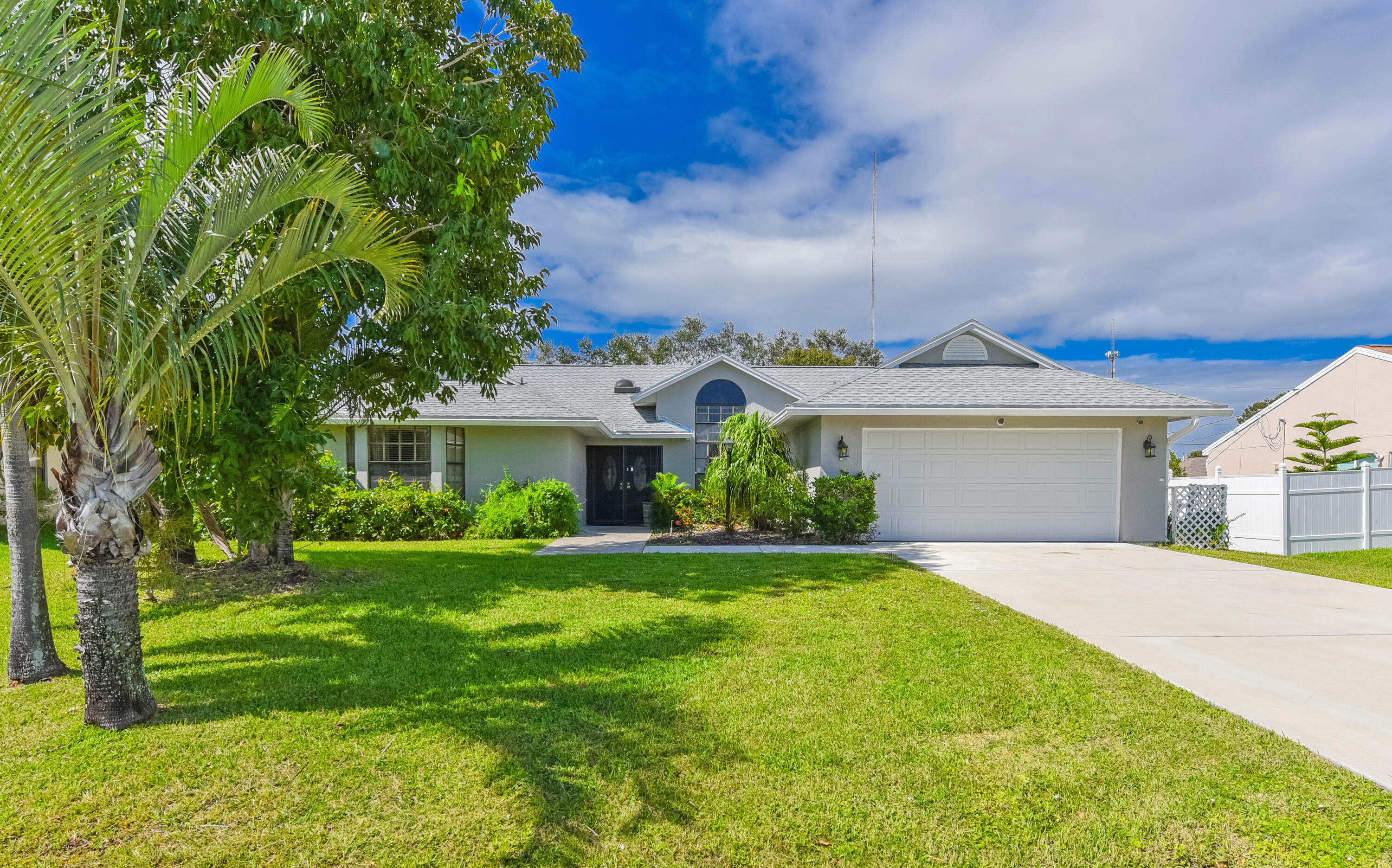 a front view of a house with a yard and trees