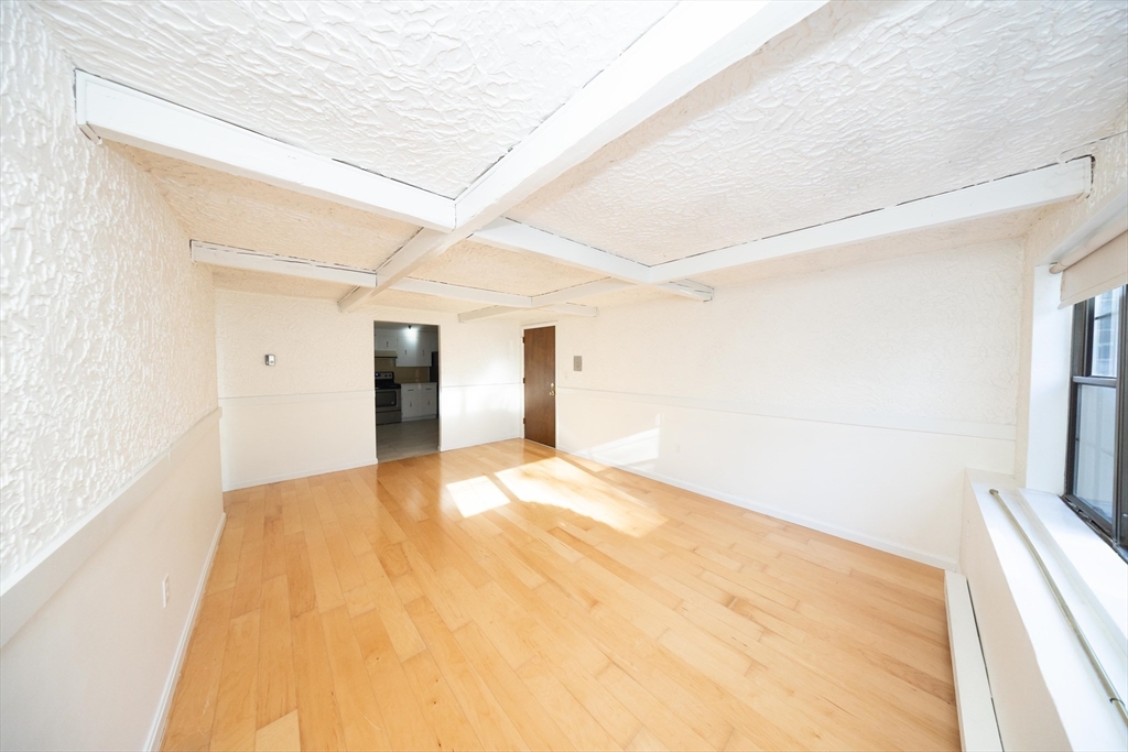 a big room with wooden floor and natural light