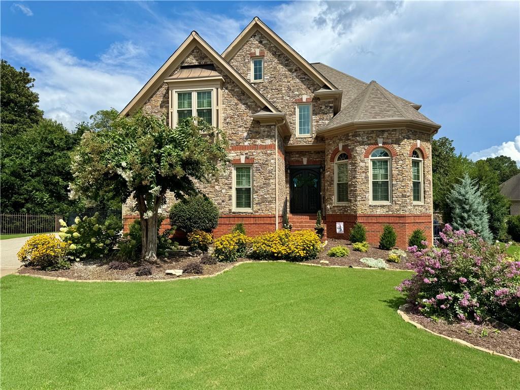 a front view of a house with a yard and trees