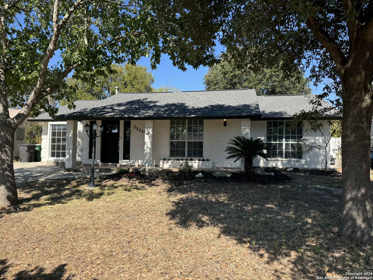 a front view of a house with a garden and patio