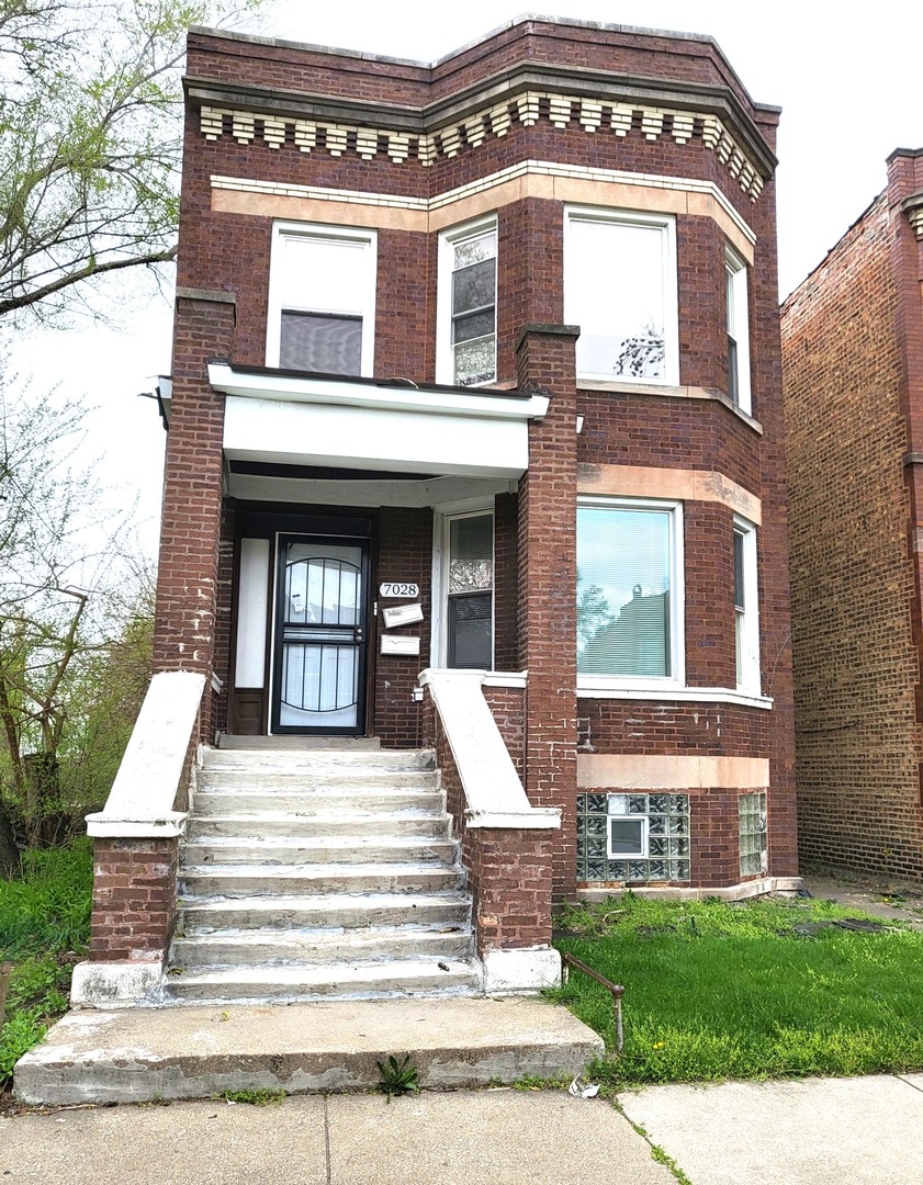 a view of a brick house with large windows