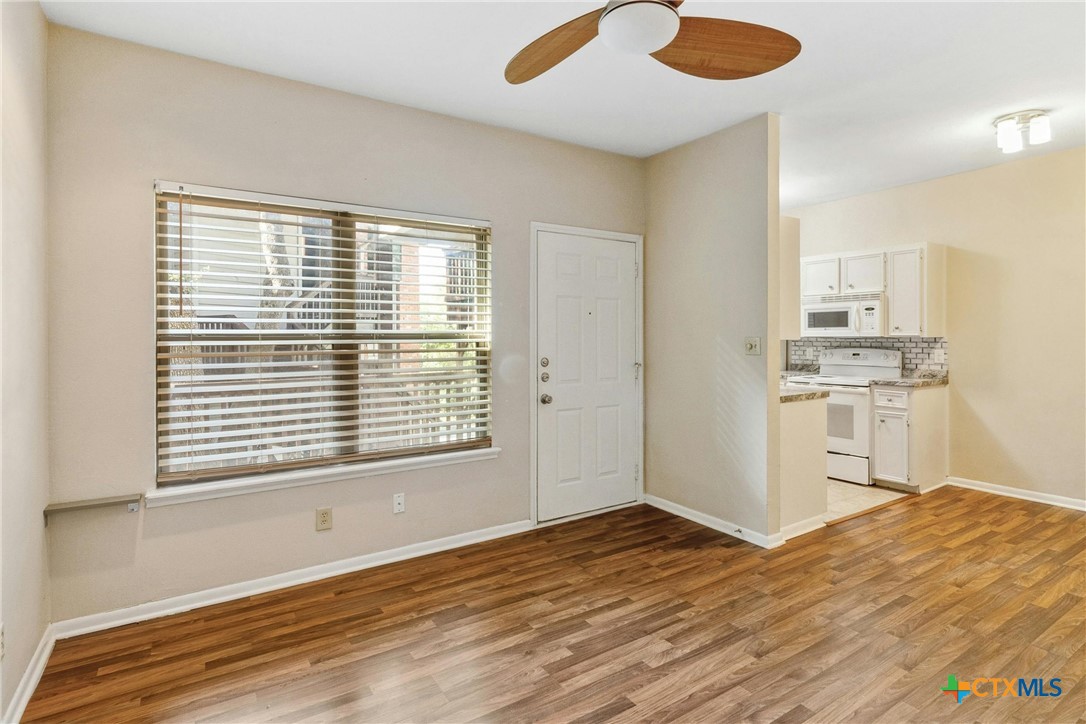 a view of a kitchen with wooden floor and a window