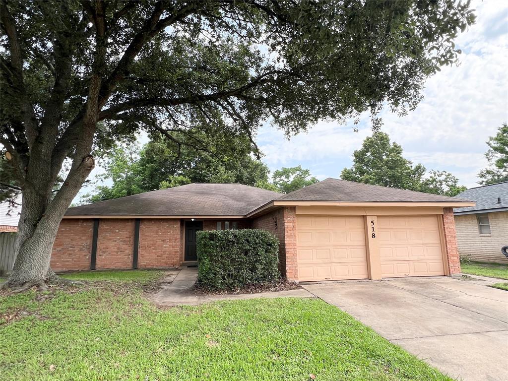 a view of a house with a yard and large tree