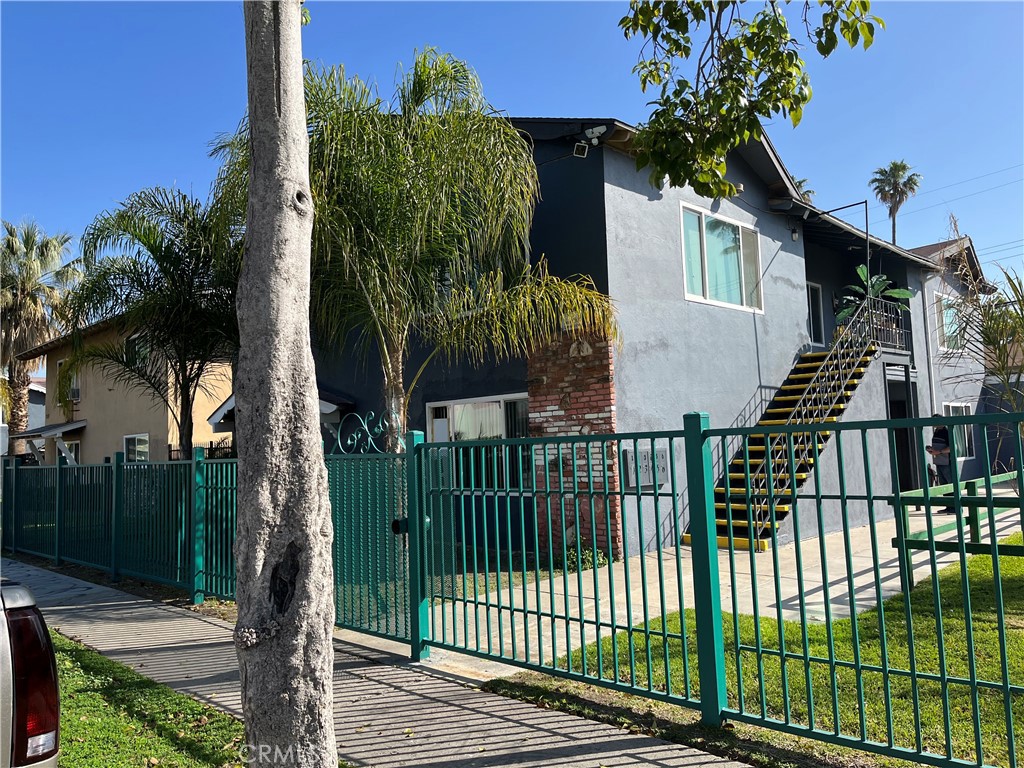 a view of a house with a small yard and wooden fence