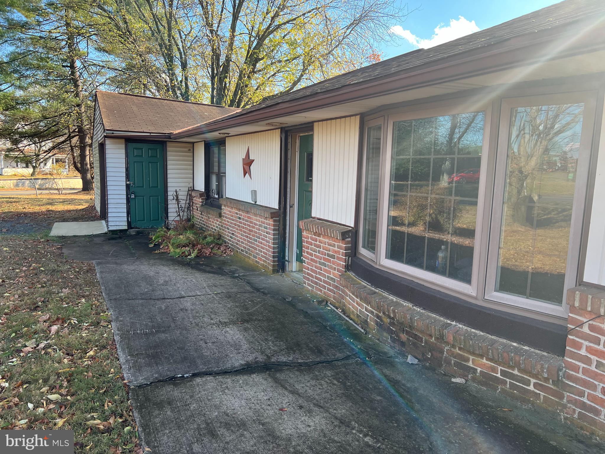 a view of a house with a yard and floor to ceiling window and large tree