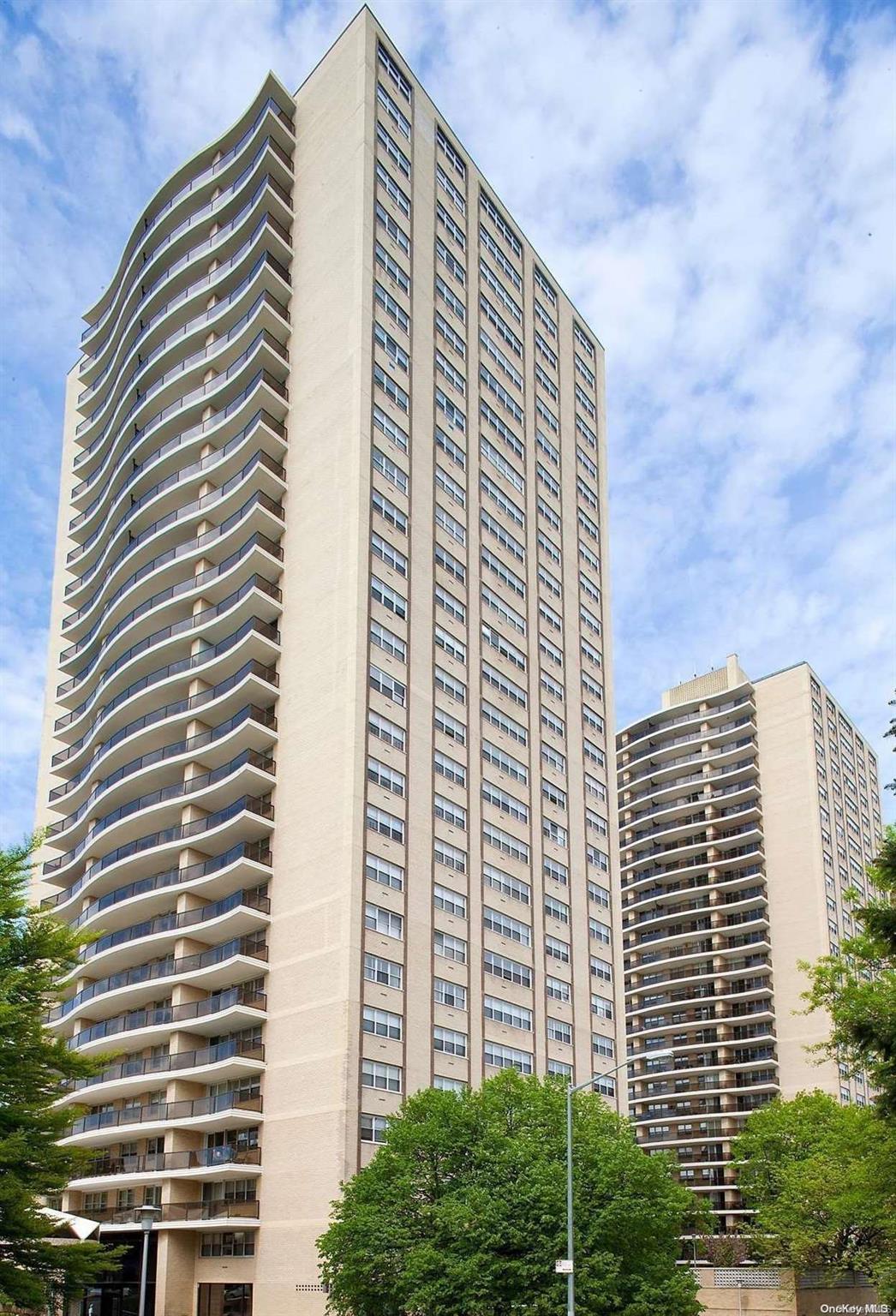 a front view of a building with plants and entryway