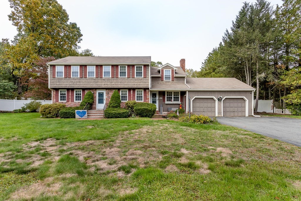 a front view of a house with yard and green space