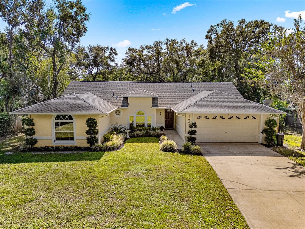 a view of a house with a big yard and large trees