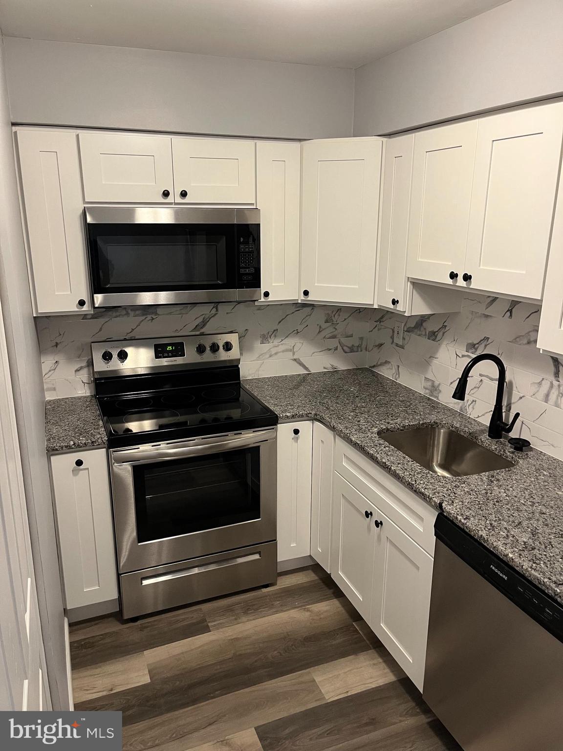 a kitchen with granite countertop a stove and a sink