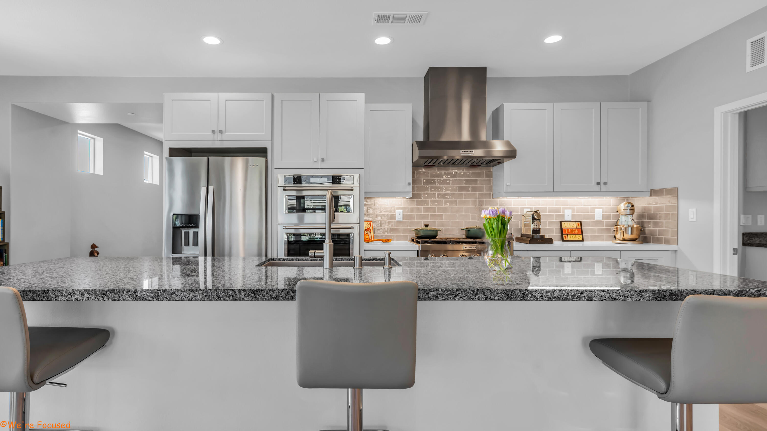 a kitchen with stainless steel appliances granite countertop a sink refrigerator and cabinets