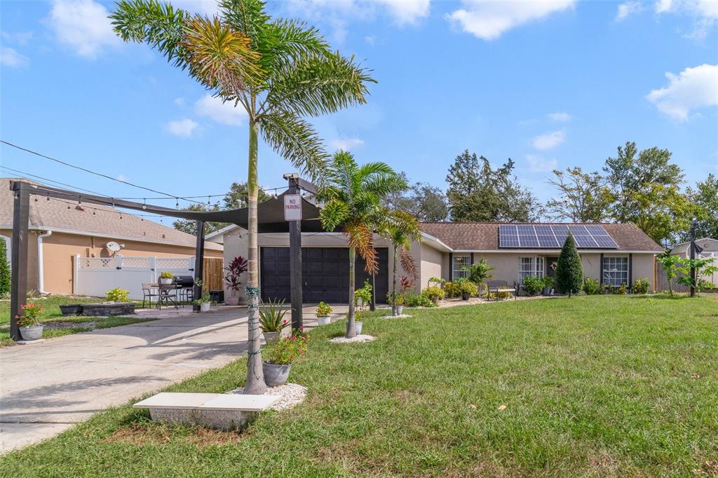 a front view of a house with a yard and tree