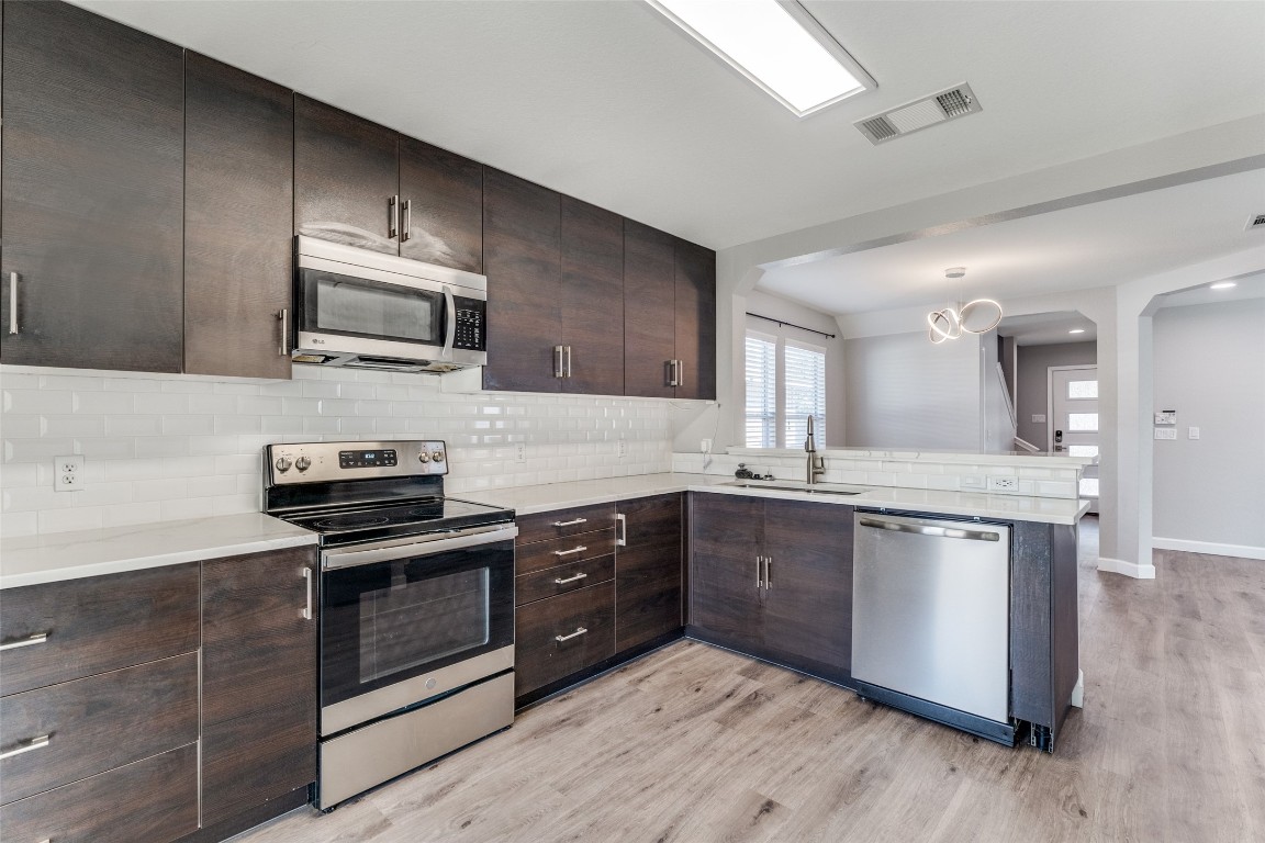 a kitchen with stainless steel appliances a stove sink microwave and cabinets