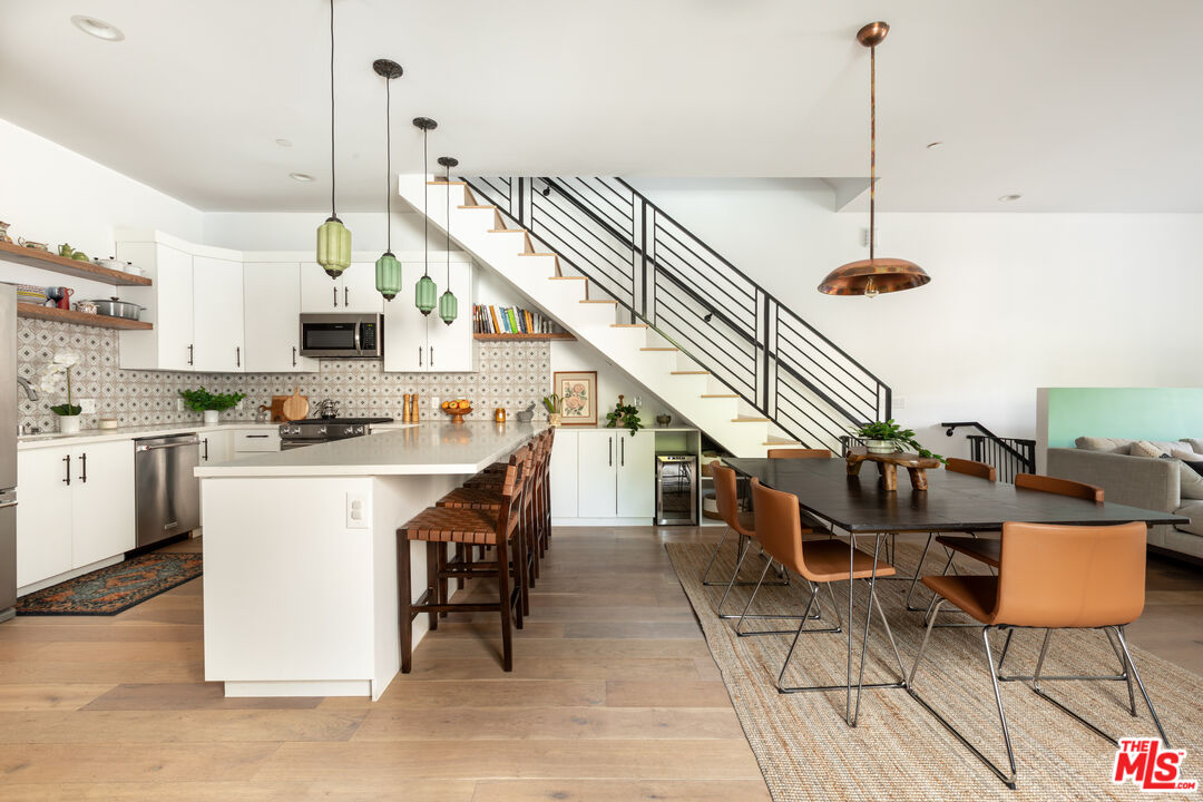 a kitchen with stainless steel appliances kitchen island granite countertop a stove a sink and a refrigerator