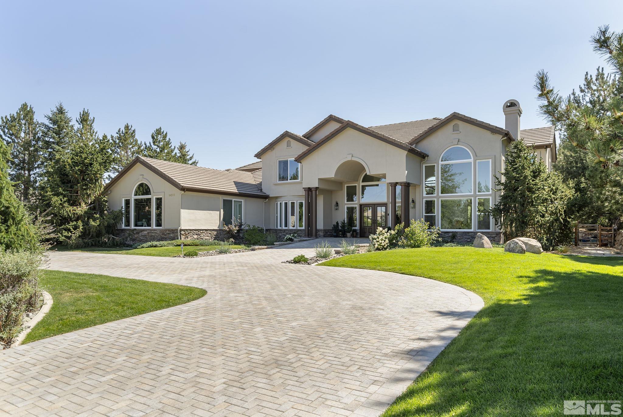 a front view of a house with a yard and trees