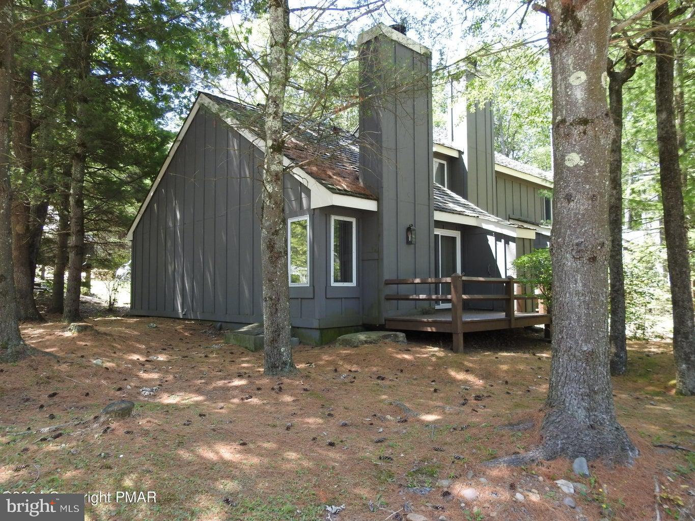 a view of a house with backyard and a tree