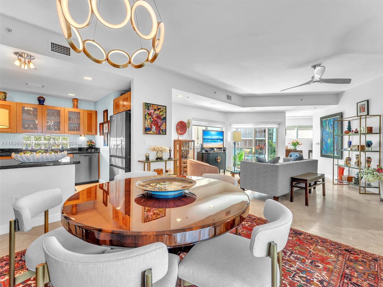 a dining room with furniture a kitchen view and a chandelier