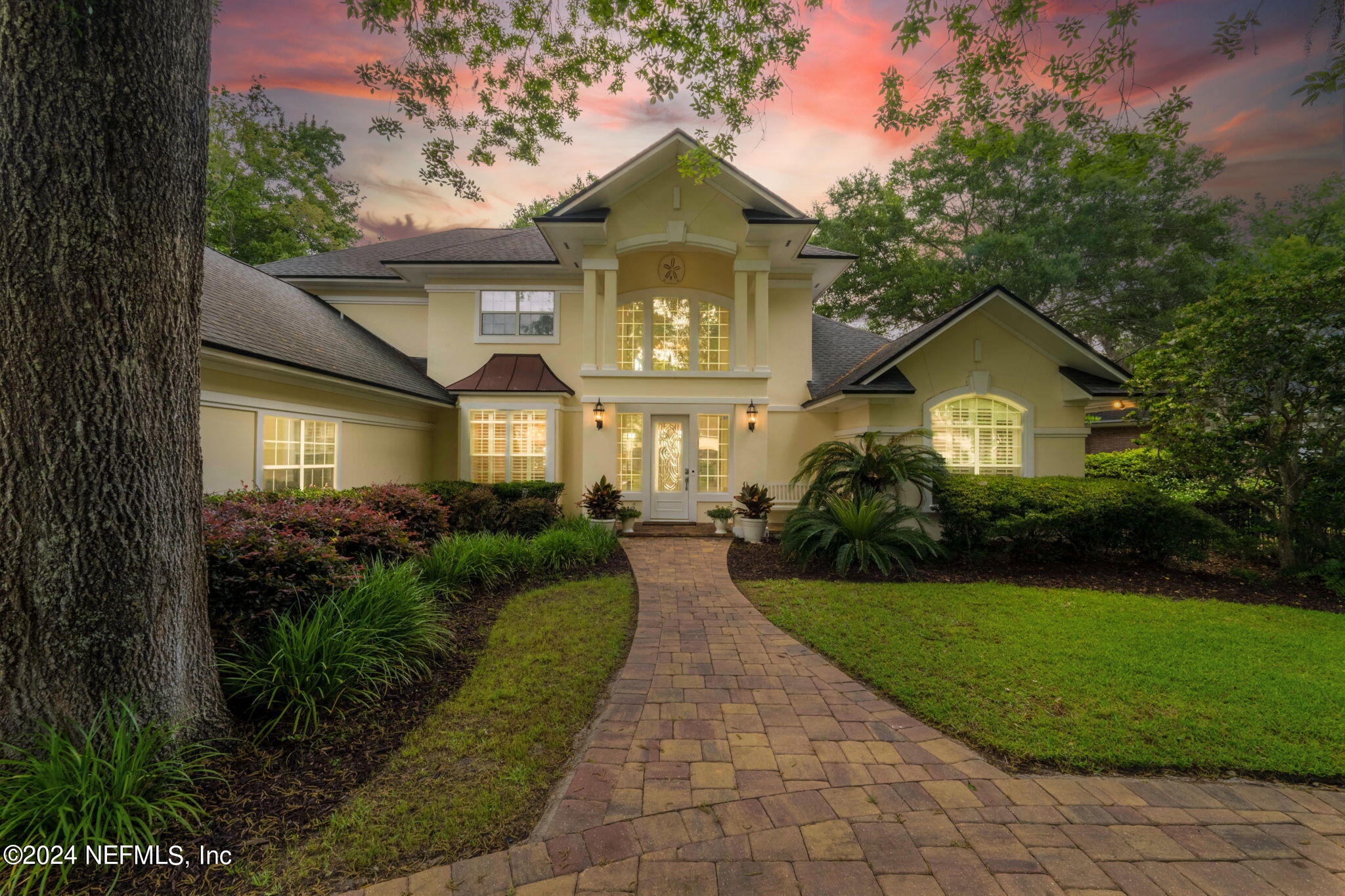 a front view of a house with a yard and potted plants