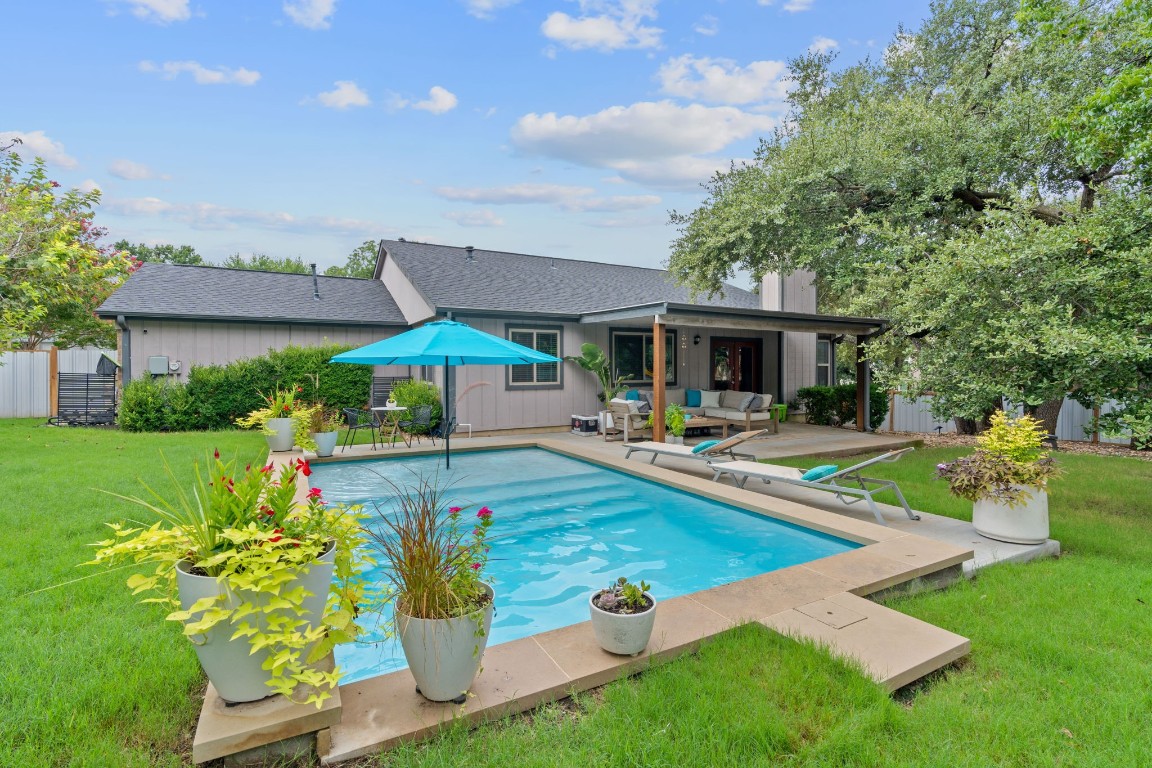 a view of swimming pool with outdoor seating and a garden