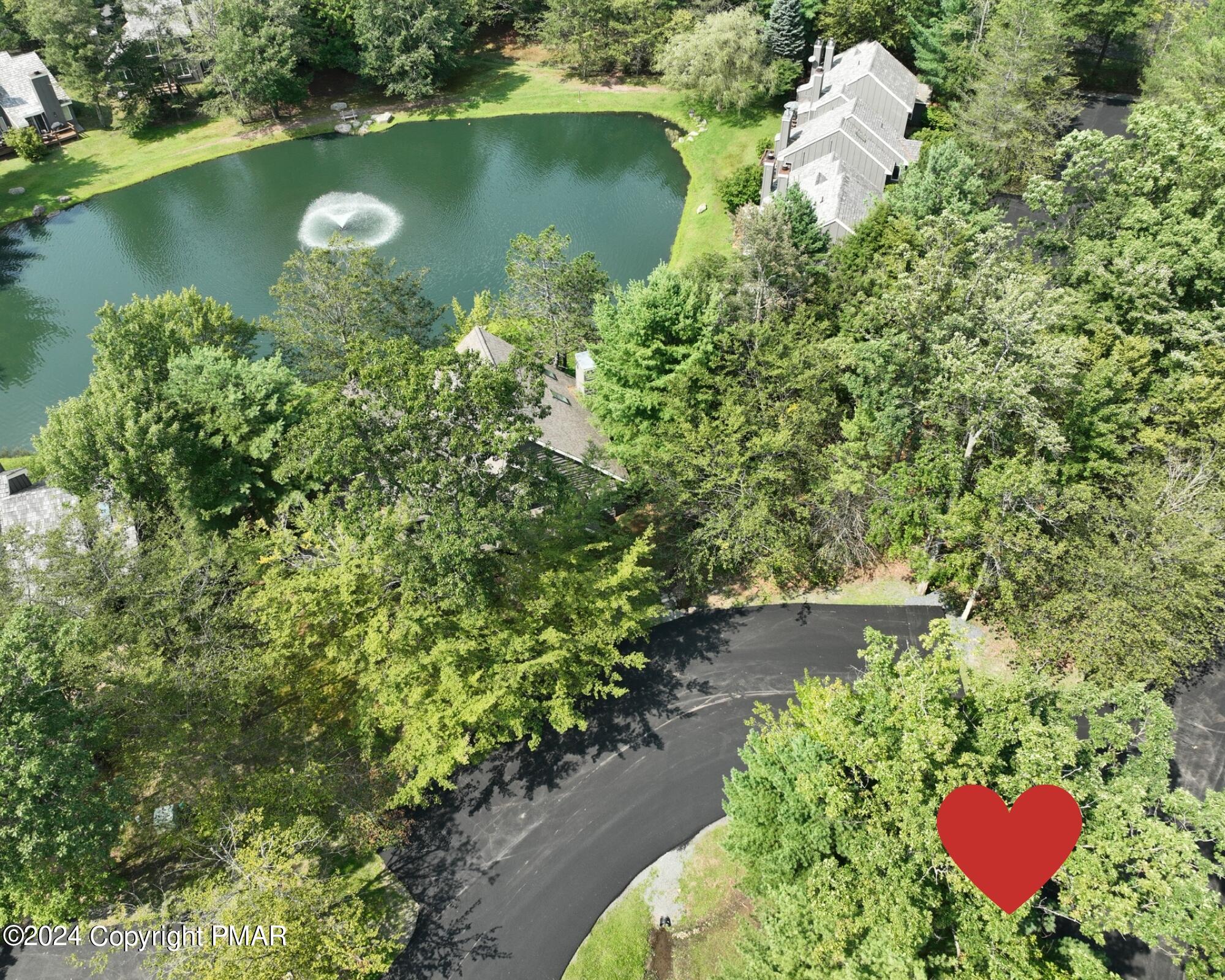 an aerial view of a house with a yard and lake view