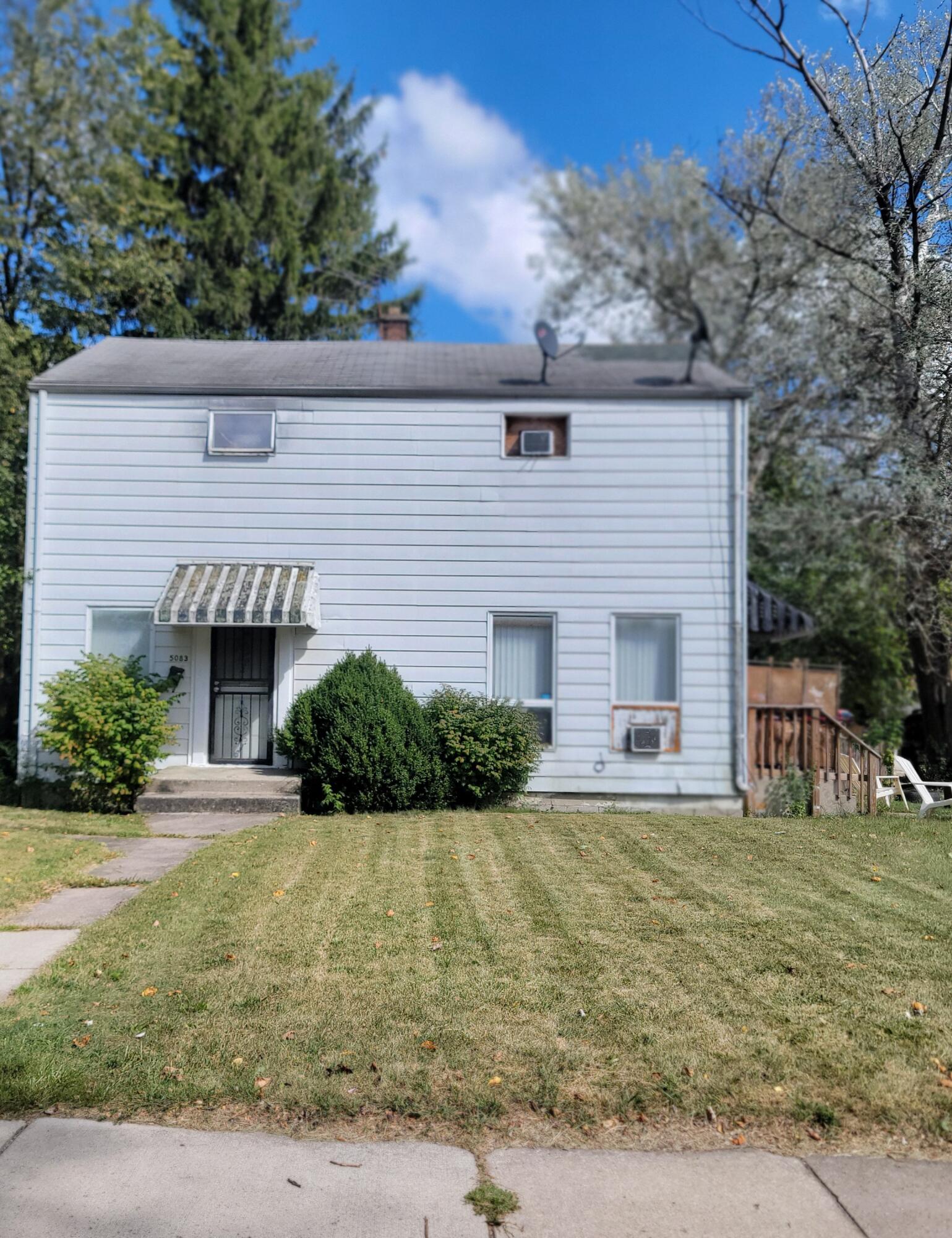 a view of house with yard and potted plants