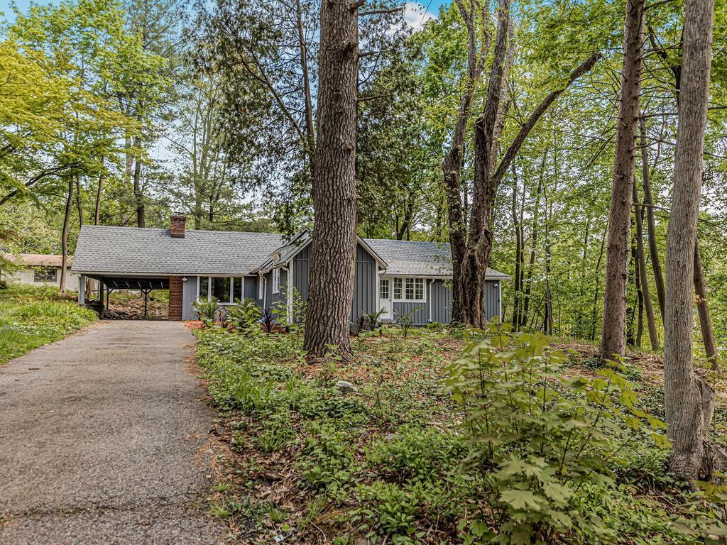 a view of a house with a large tree and a yard