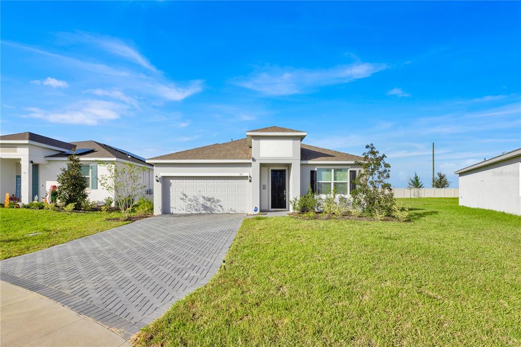 Front of the home with long brick paver driveway