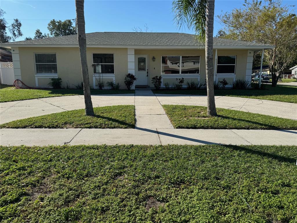 a front view of a house with a yard and potted plants