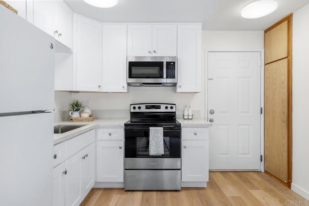 a kitchen with white cabinets and stainless steel appliances