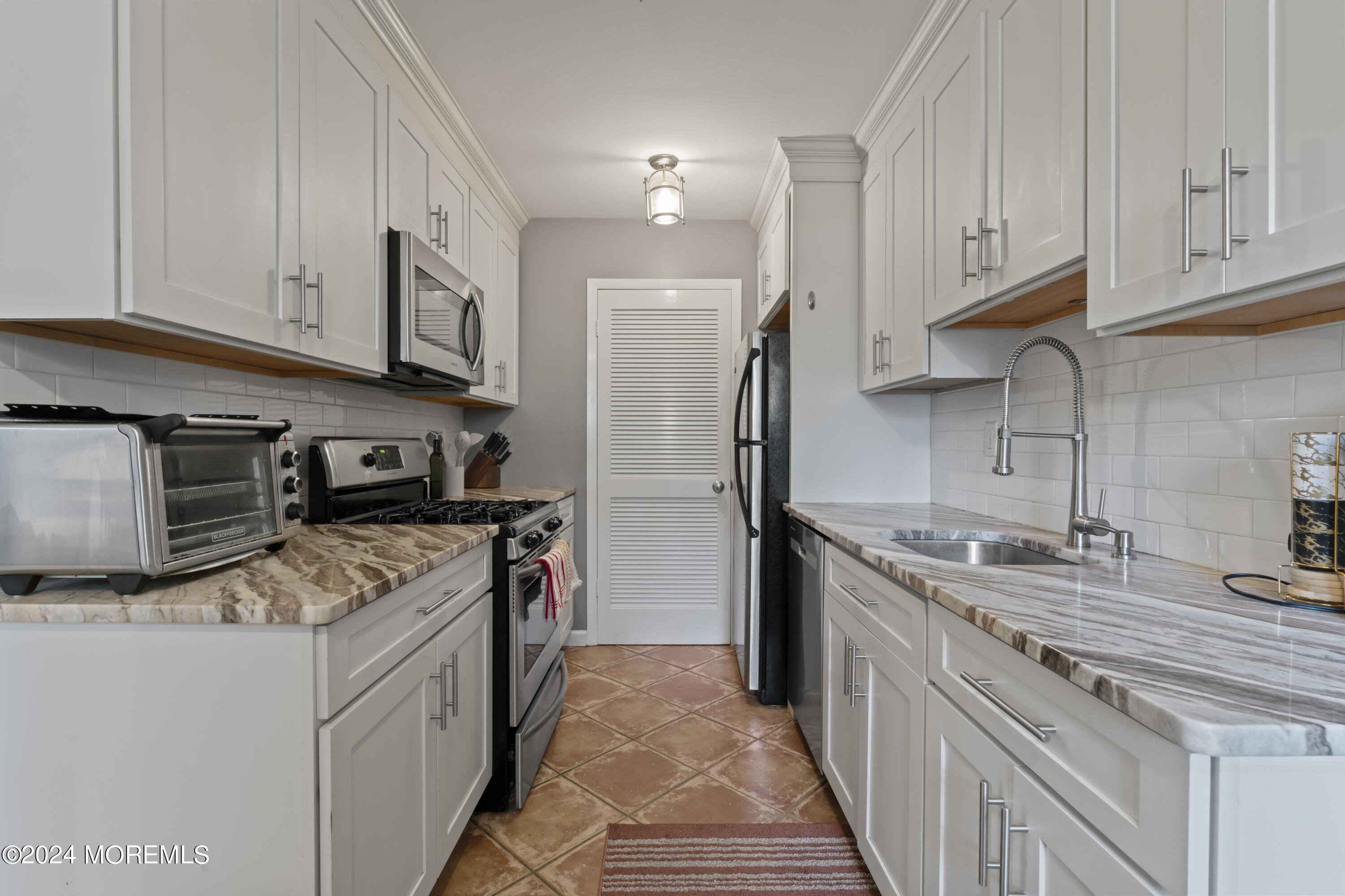 a kitchen with stainless steel appliances granite countertop a sink stove and refrigerator