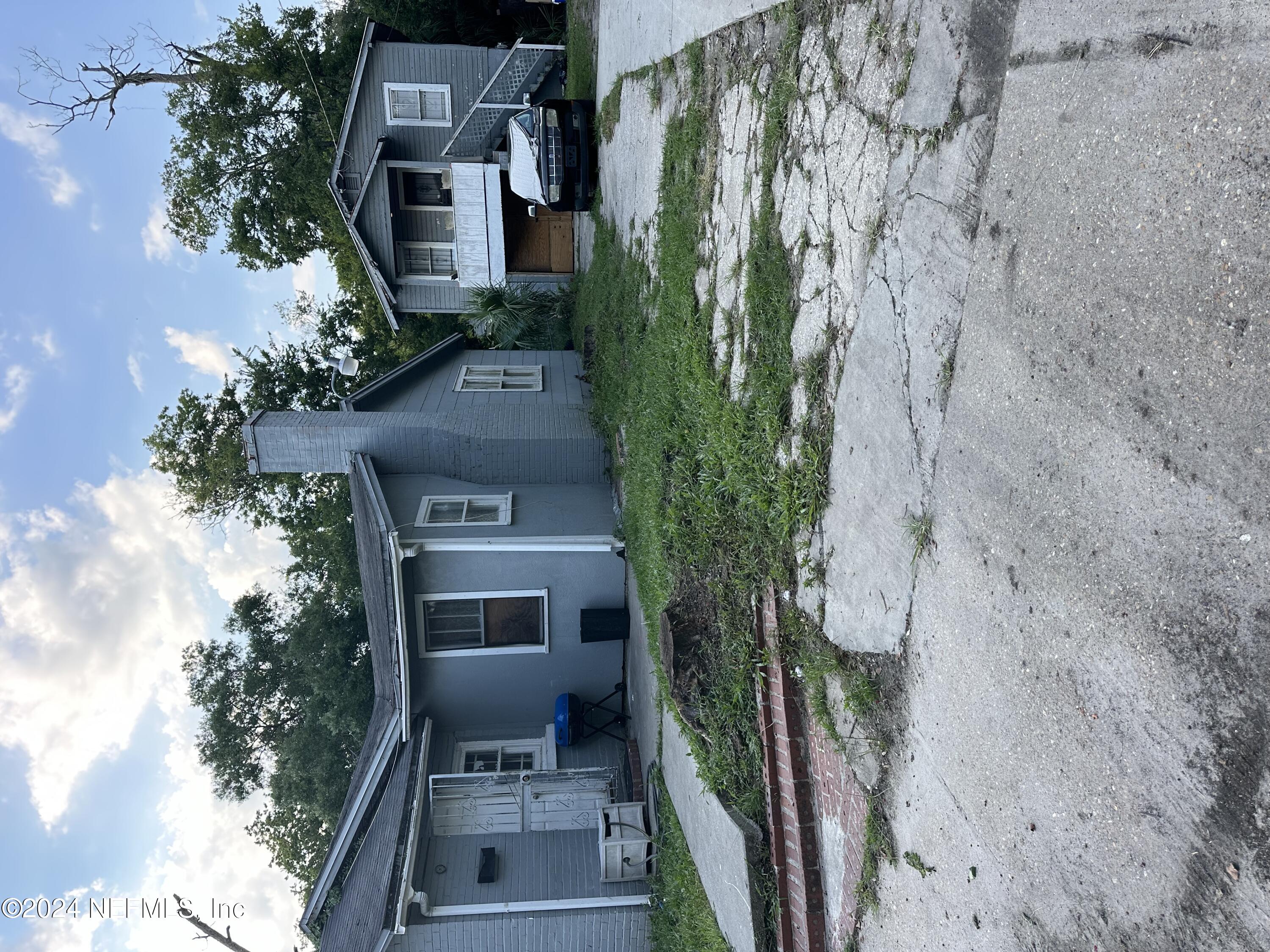 a view of house with backyard and a garden