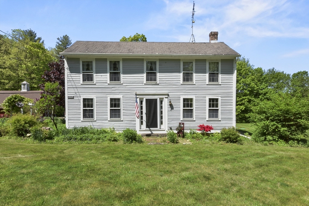 a front view of a house with plants and garden