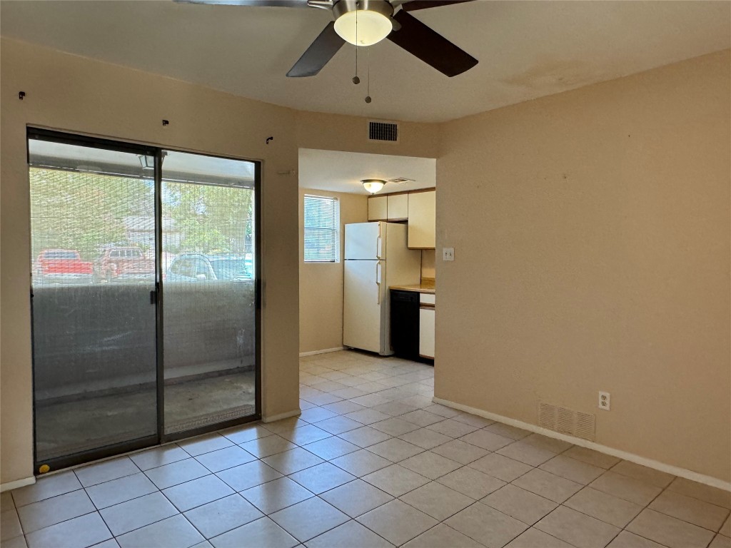 a view of a refrigerator in kitchen and an empty room