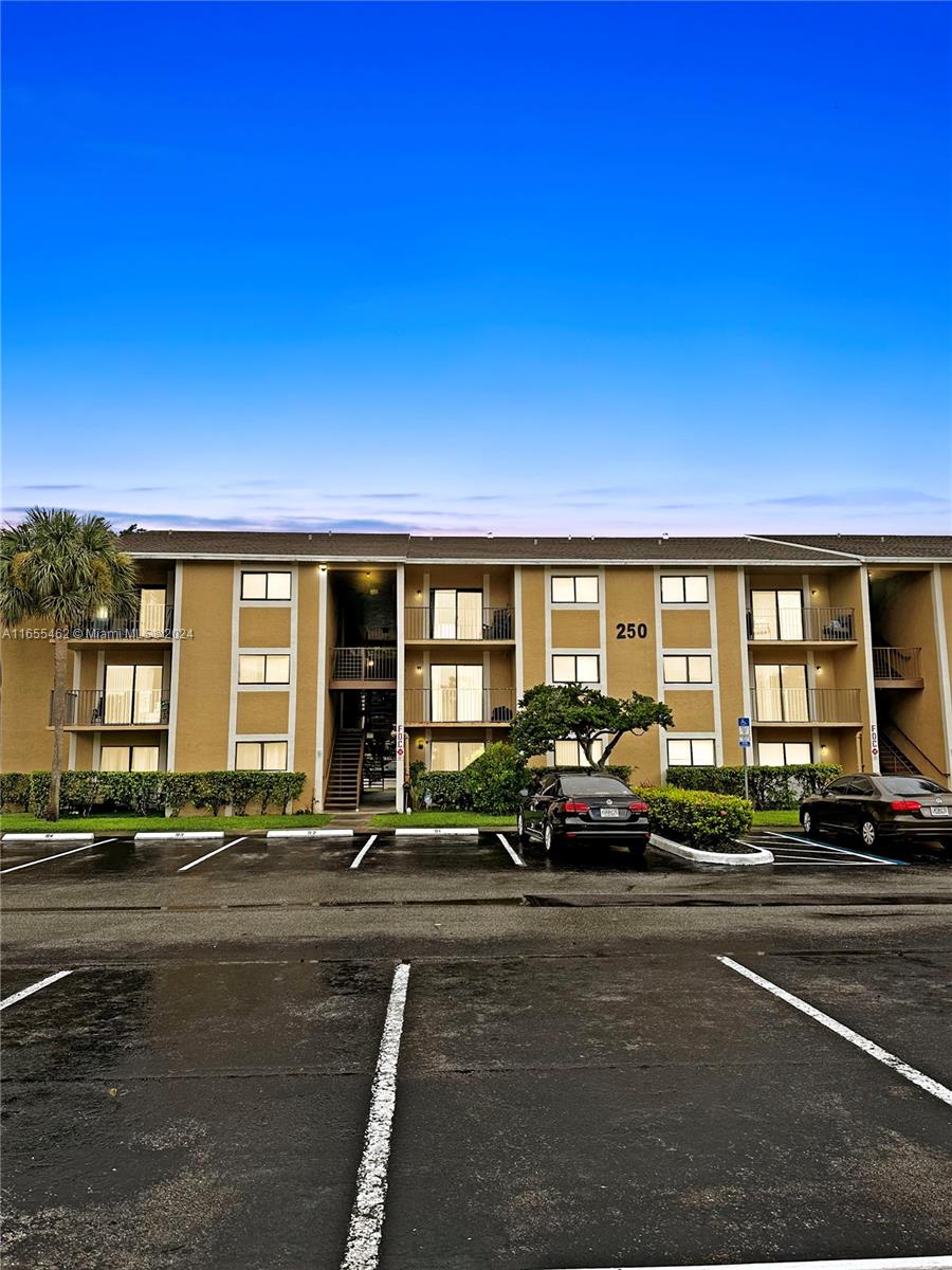 a view of building with cars parked