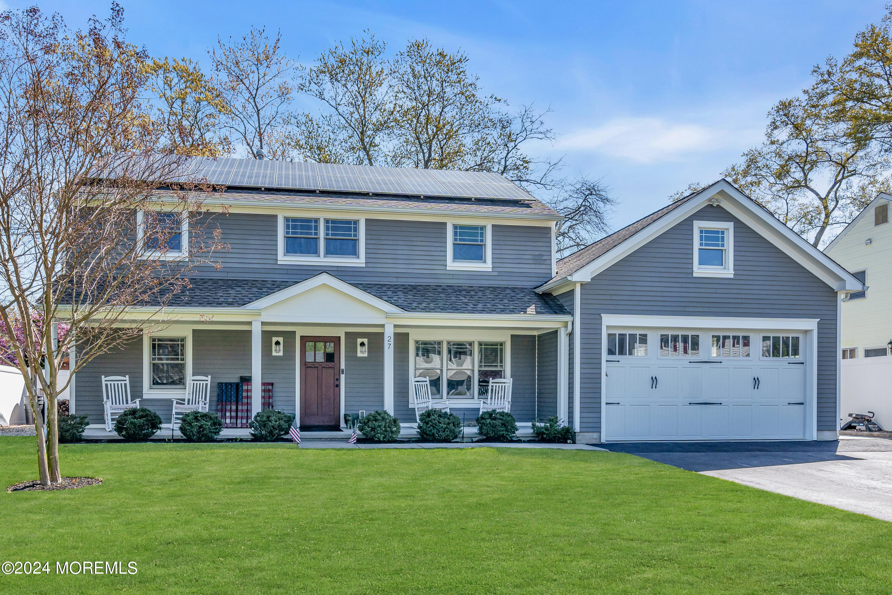 a view of a brick house with a big yard and large trees