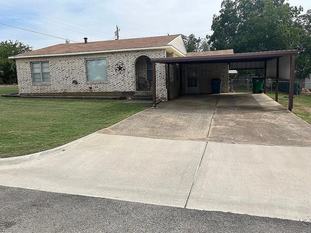 a front view of a house with a garden and yard