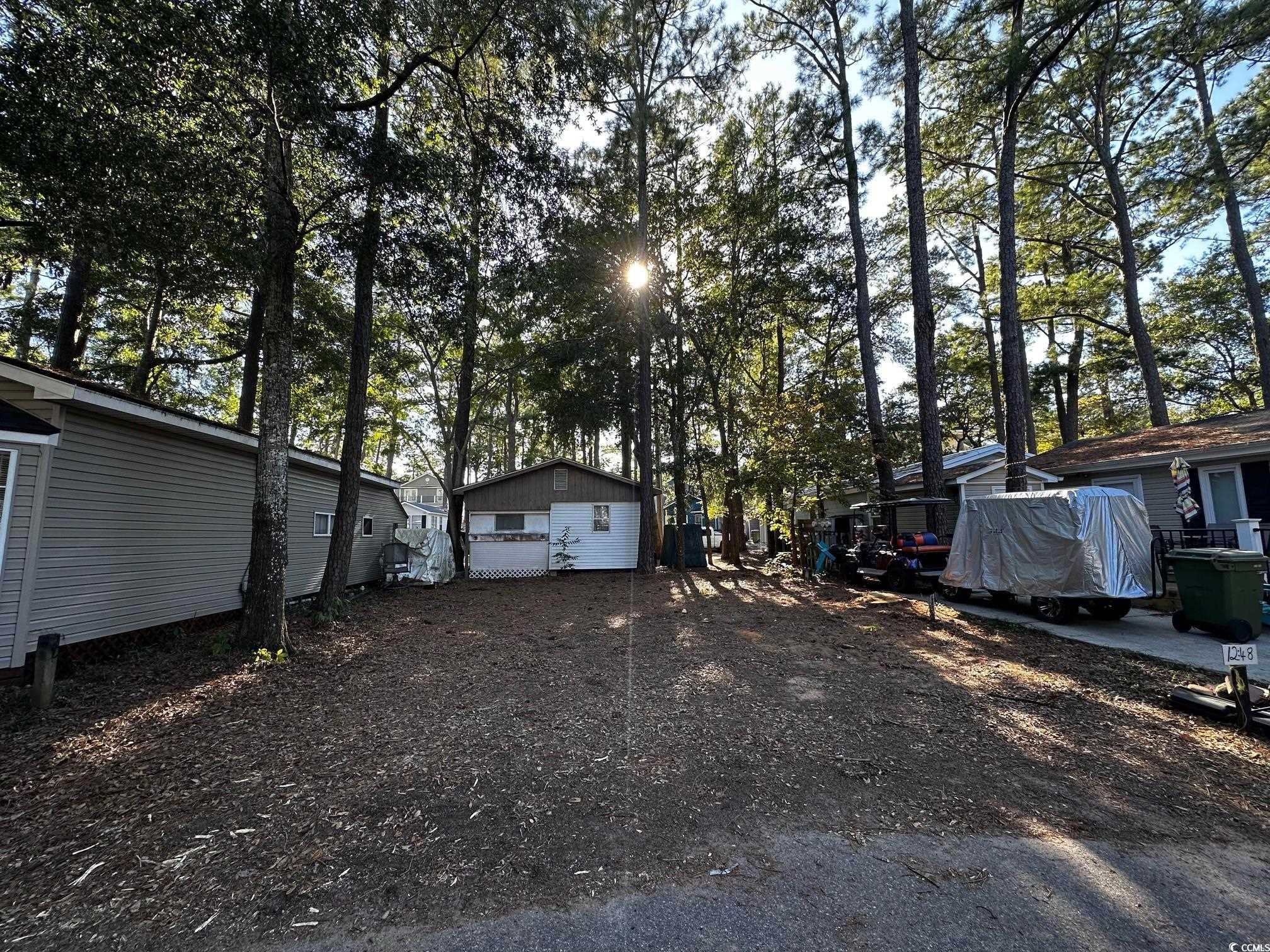 View of yard with a garage and an outbuilding