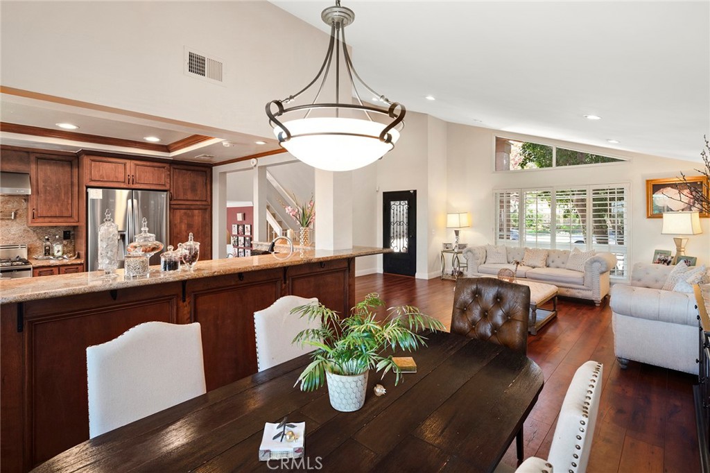 a dining room with furniture a chandelier and wooden floor