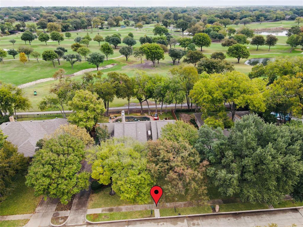 an aerial view of residential house with outdoor space and trees all around