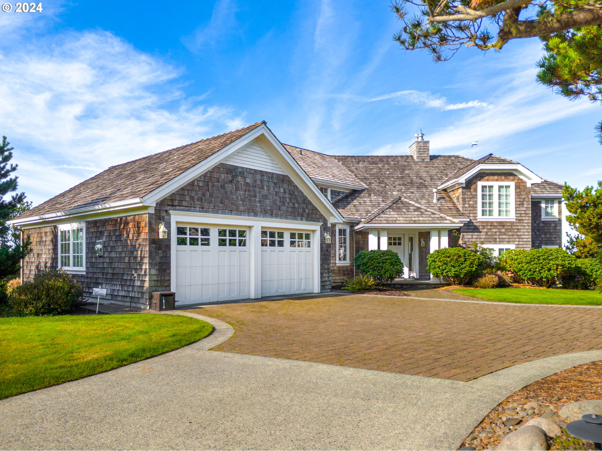 a front view of a house with a garden and yard