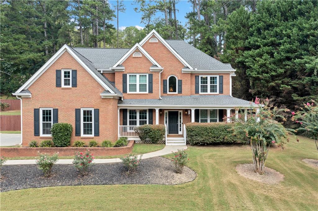 a front view of a house with a yard and trees