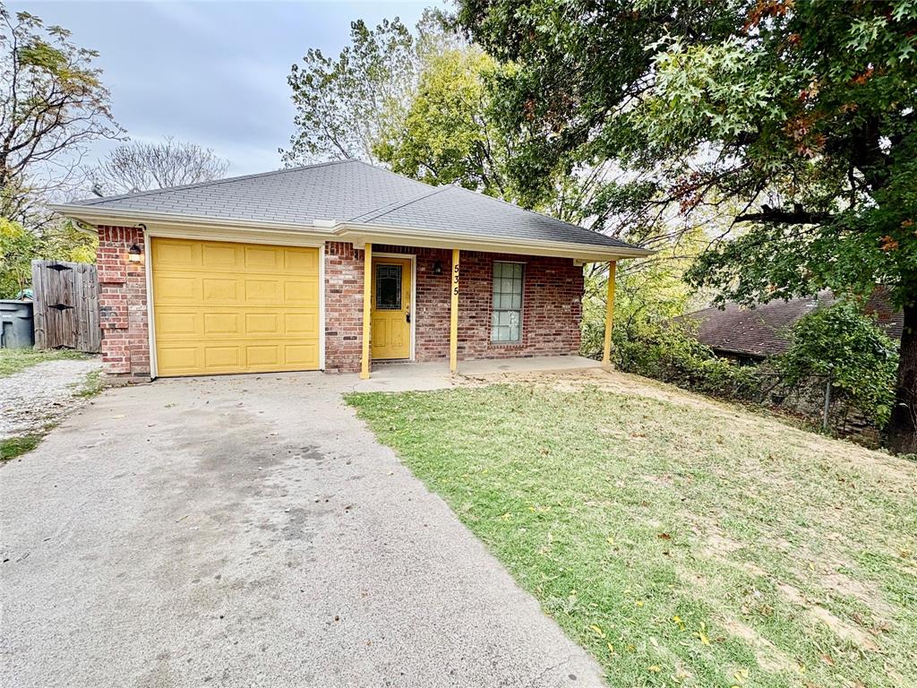 a front view of a house with yard and garage