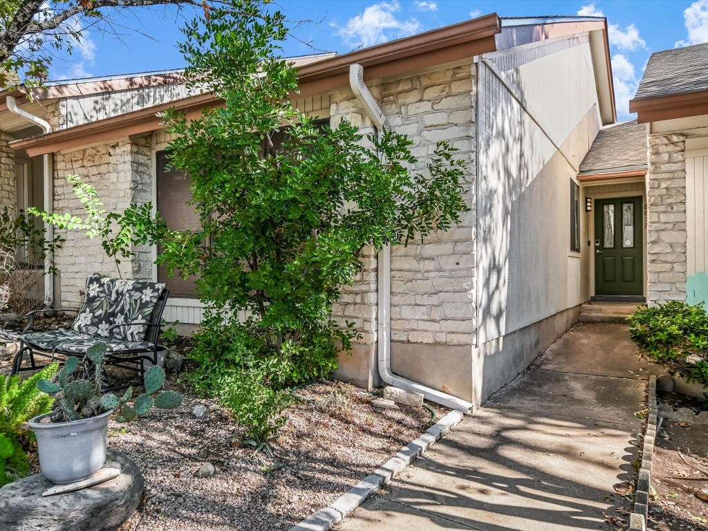 a view of a house with a yard and potted plants