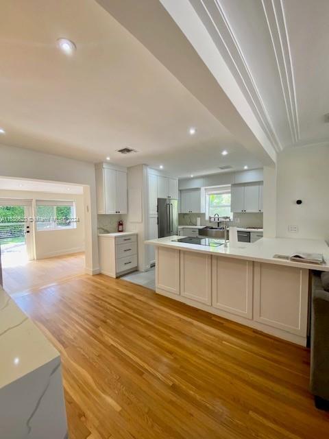 a large kitchen with stainless steel appliances granite countertop a large counter top and a wooden floors