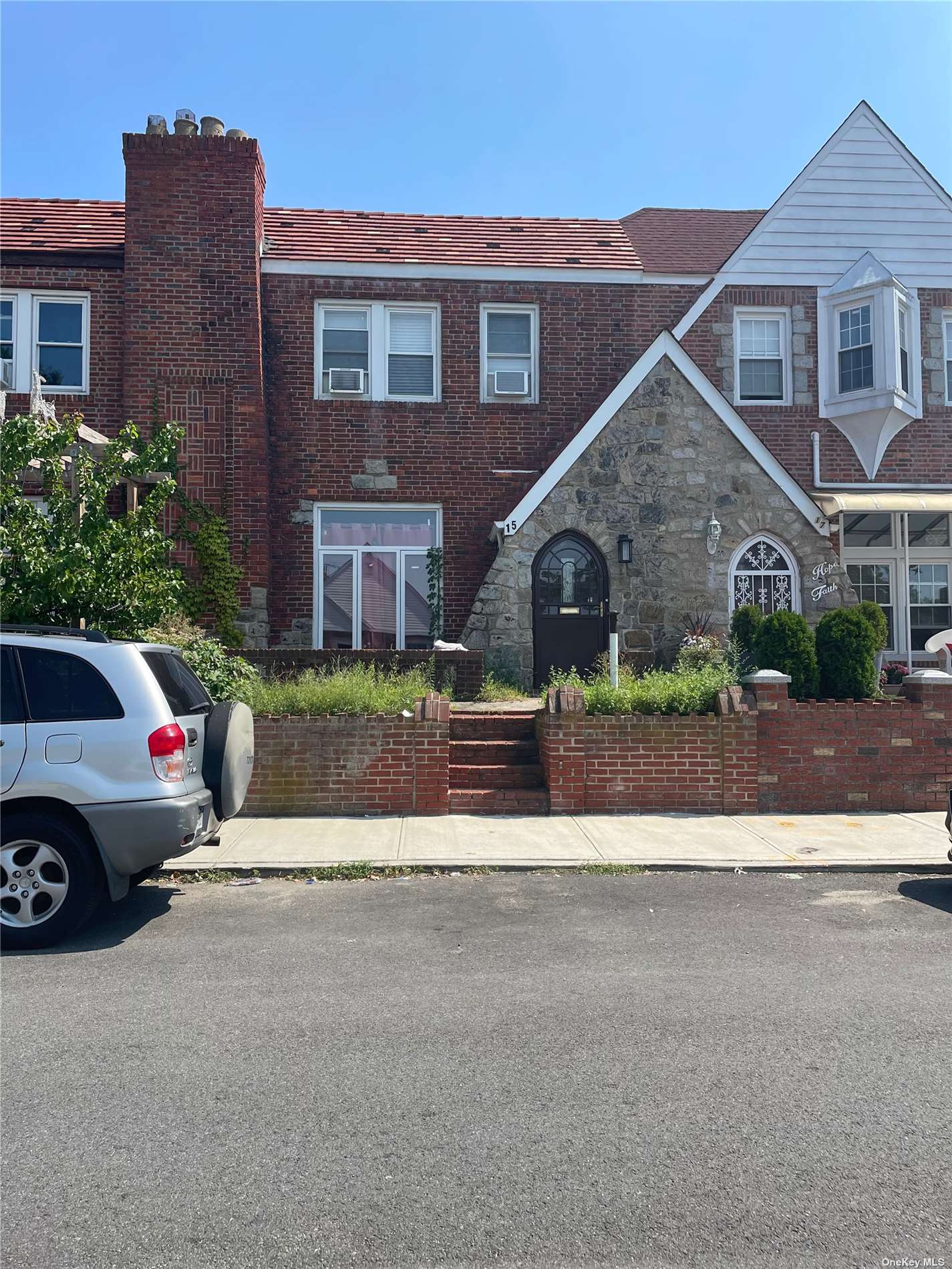 a view of a car parked in front of a brick house