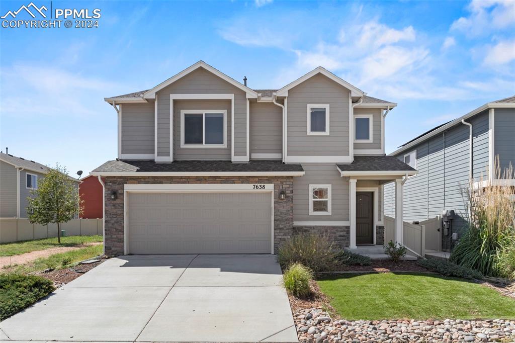 View of front of home featuring a garage and a front lawn